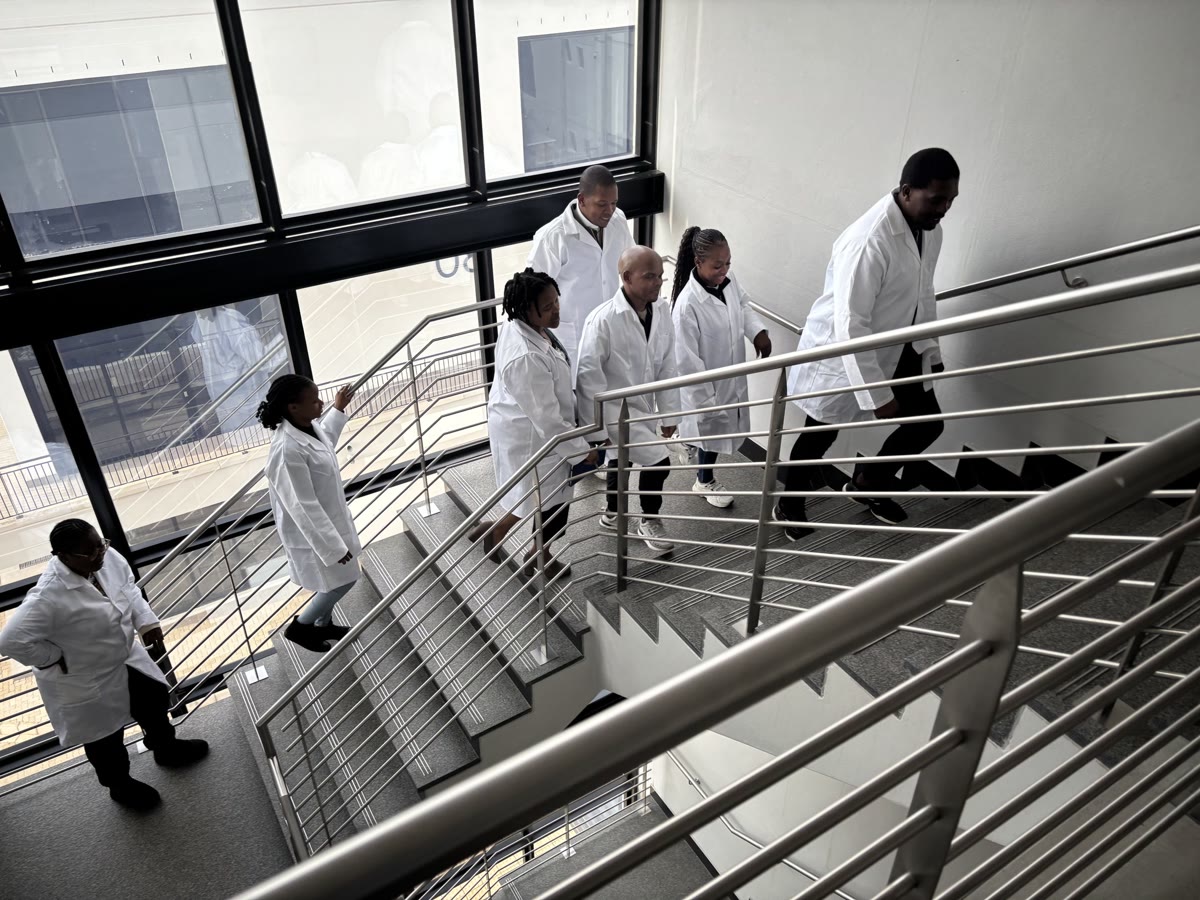 Members of the Isondo technical team on the staircase of the manufacturing facility.